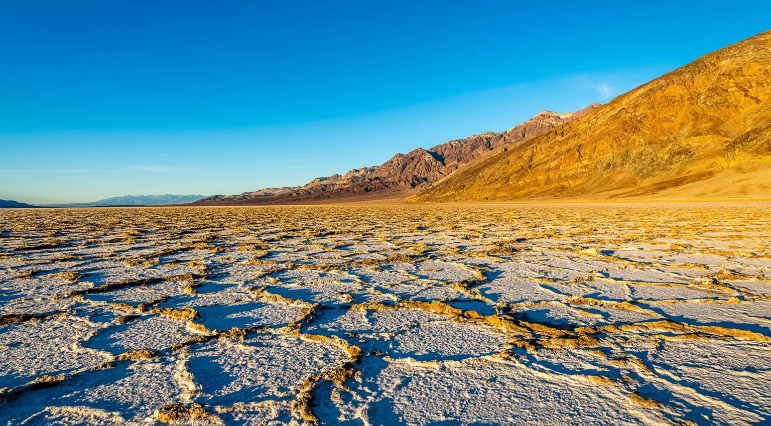Salt formations beneath rugged desert mountains