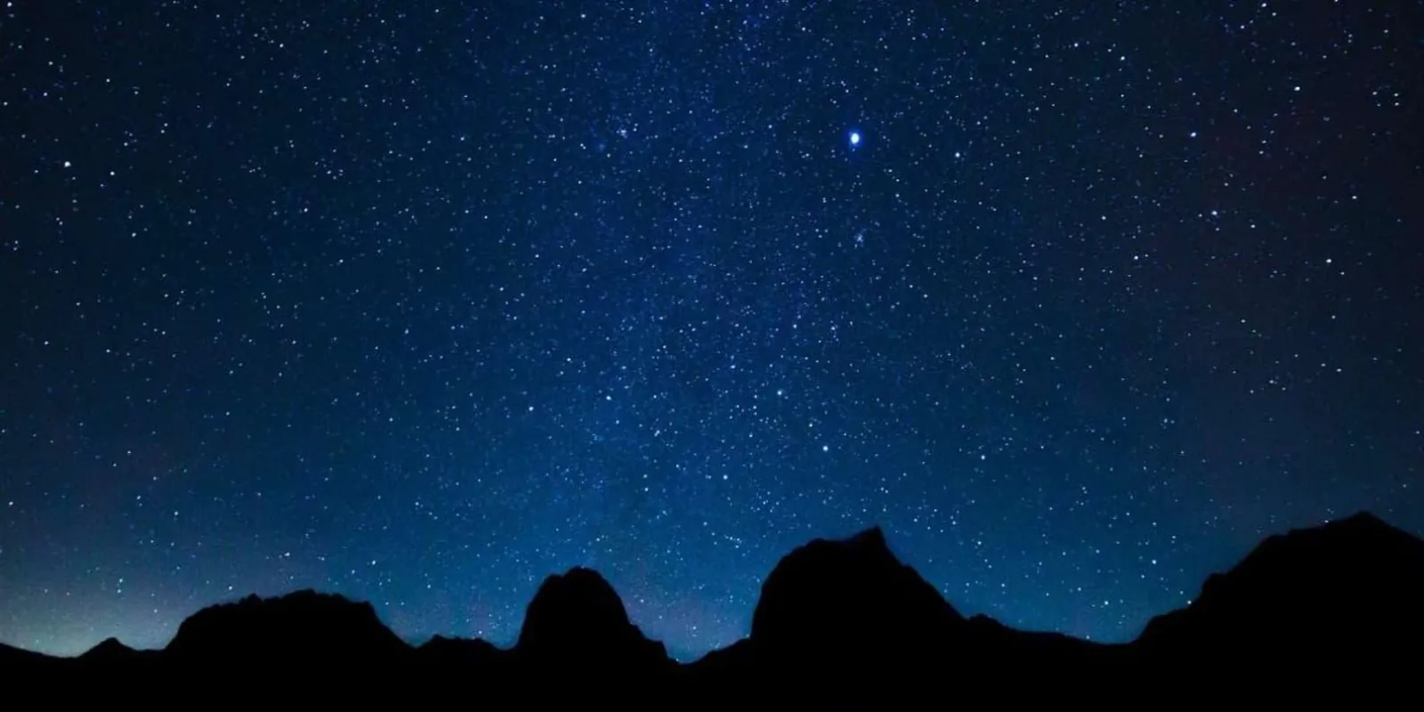 Stars above a desert rock silhouette