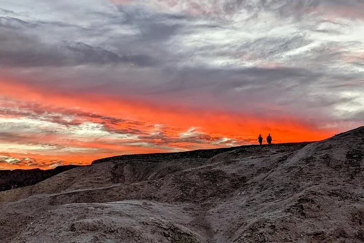 Red sunset sky above desert badlands