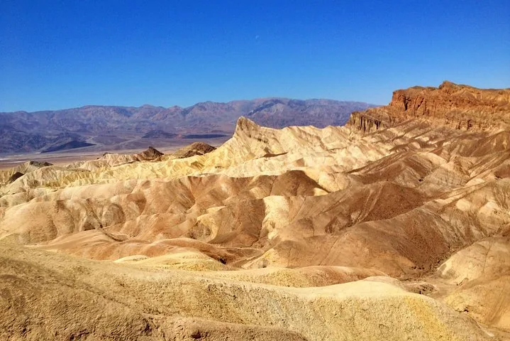 Golden badlands beneath clear sky